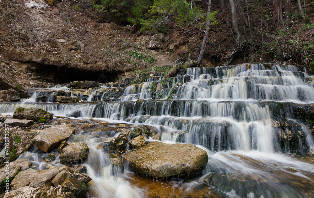 Obraz premium Panorama of the waterfall emanating from under ground on the river Poneretka