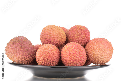 Several juicy sweet litchi fruit on a ceramic plate, close-up, isolated on white.