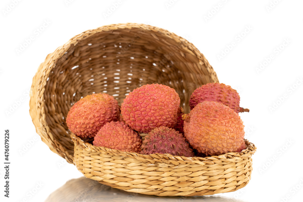 Several ripe organic litchi fruit with straw dishes, close-up, isolated on white.