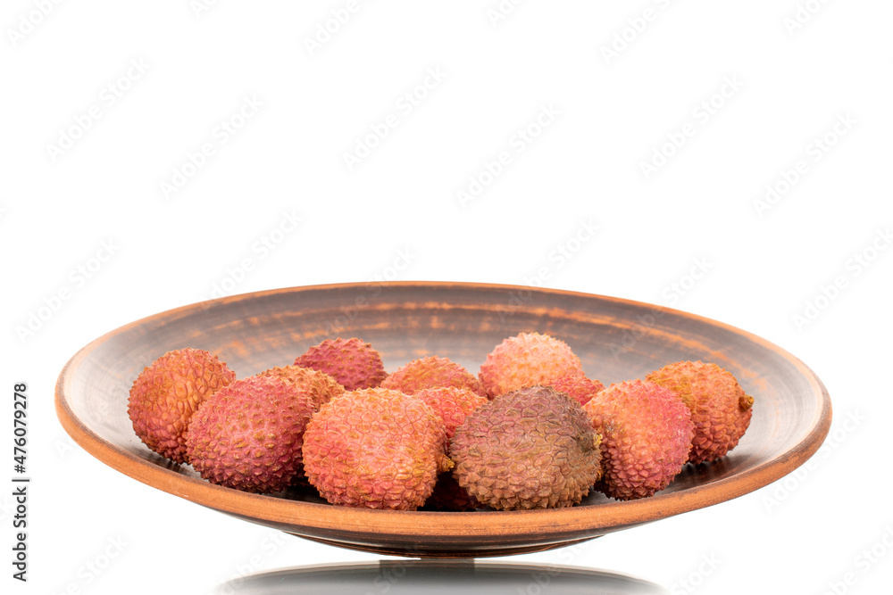 Several juicy sweet litchi fruit on a clay plate, close-up, isolated on white. Several juicy sweet litchi fruit on a clay plate, close-up, isolated on white.