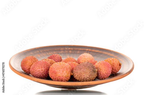 Several juicy sweet litchi fruit on a clay plate, close-up, isolated on white.