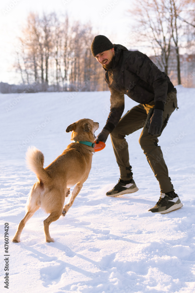 Young man walking and playing with red hair dog outside. Young man walking and playing with red hair dog outside.