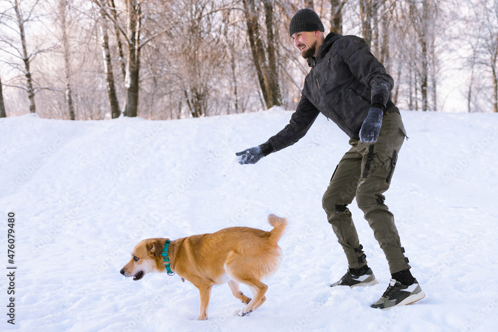 Young man walking and playing with red hair dog outside. Young man walking and playing with red hair dog outside.