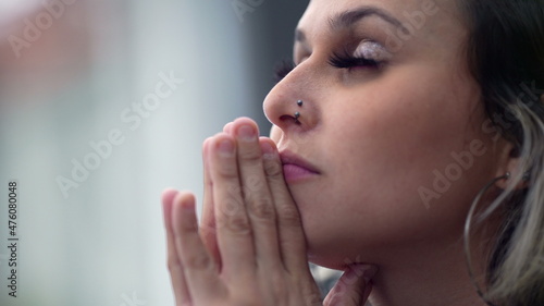 Young woman closing eyes in meditation and contemplation, person praying
