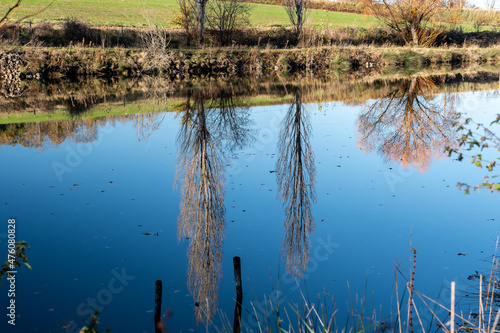 Konstfotografi Deux magnifiques peupliers se reflétant dans un petit étang en automne