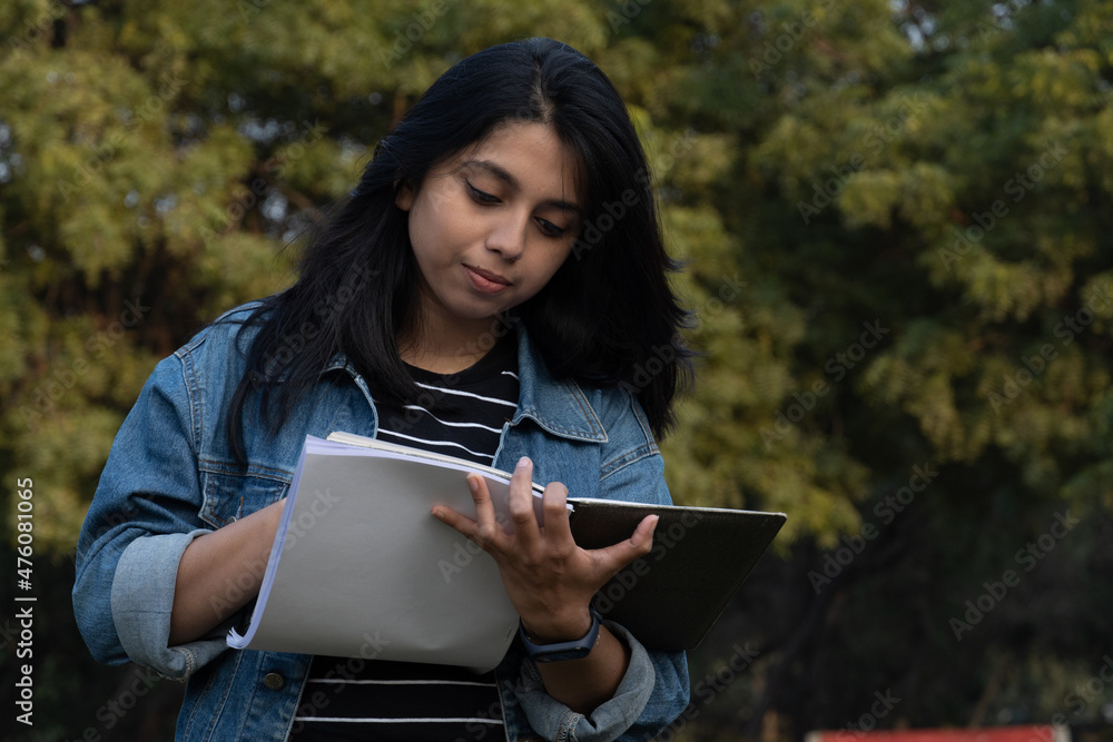 Fototapeta premium College student writing something on her notebook
