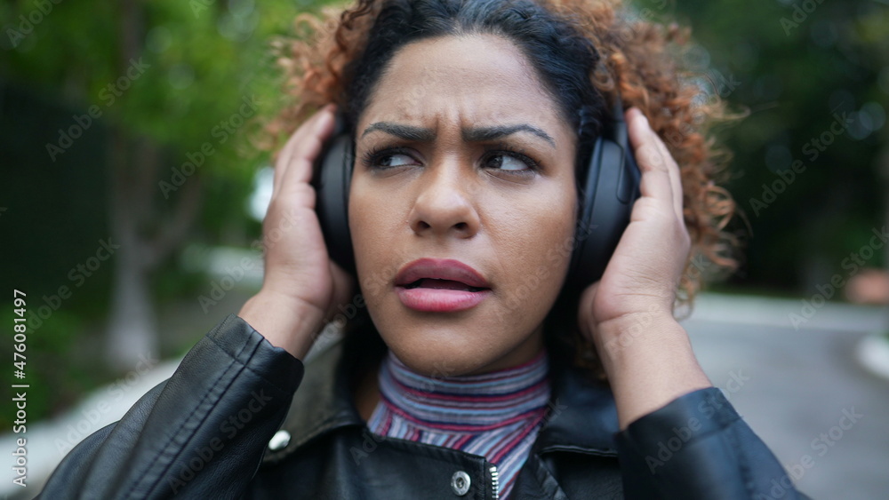Person surprised reaction listening to podcast wearing headphones, woman reacts to news with shock