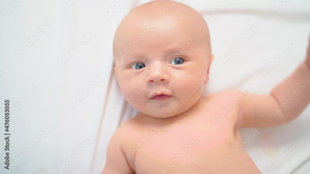 view from above. cute baby on a white sheet. view from above. cute baby on a white sheet.