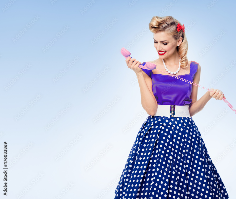 Funny portrait of beautiful woman with phone dressed in pin-up