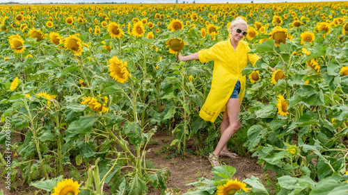 Cheerful woman in yellow dress young blue clouds in hot sunny weather girl summer joy, countryside field ress print, face flower. Outdoor background black beauty photo