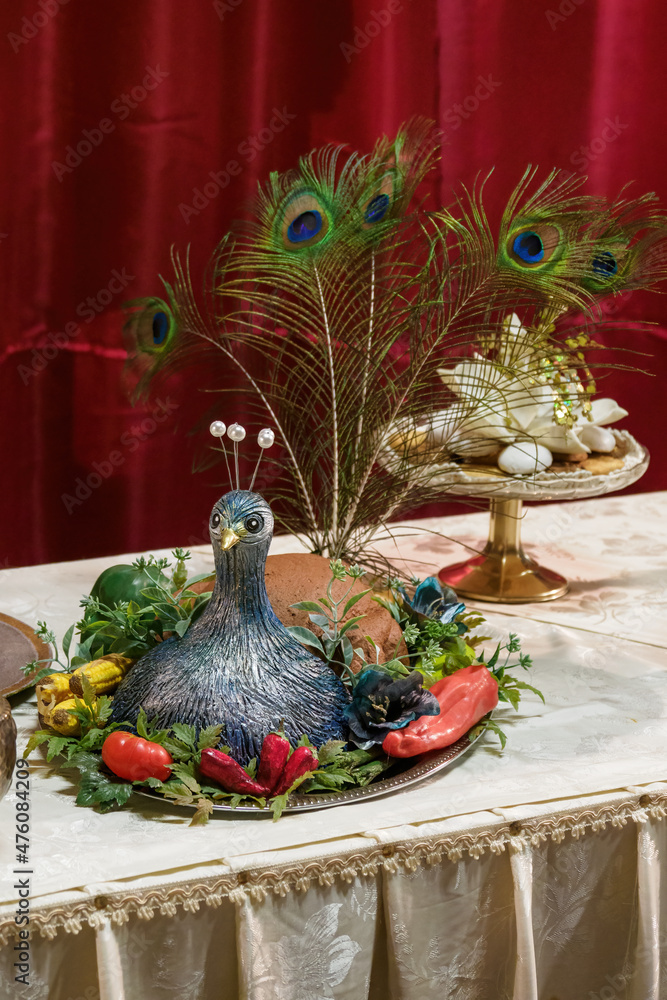Plastic peacock at a decorative feast.