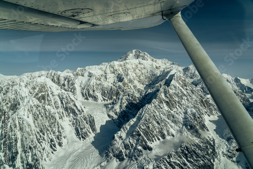 Beautiful snow covered mountains seen from small airplane photo