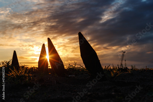 sharp corners stick out from the ground in the form of silhouettes against the sunset
