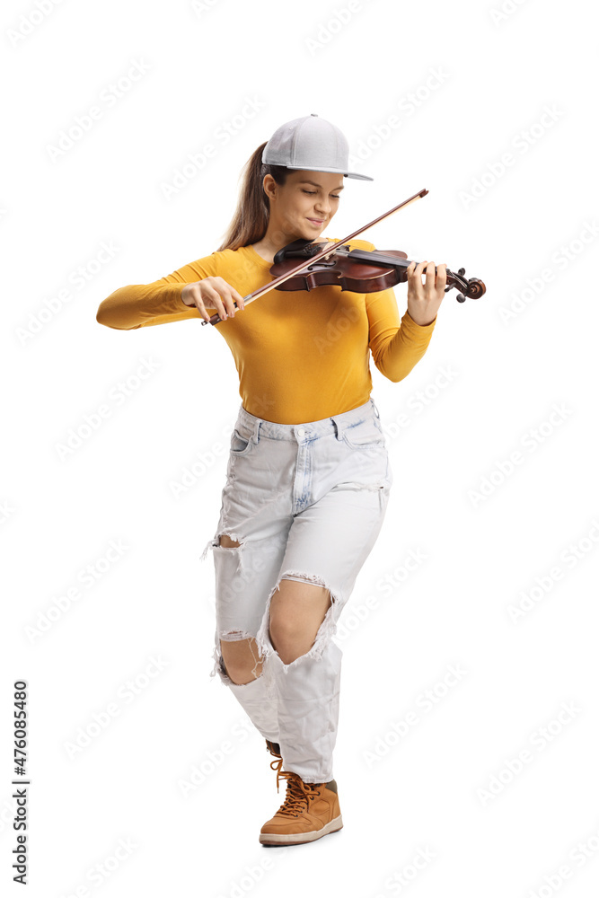 Young female violinist in jeans and yellow top playing a violin Young female violinist in jeans and yellow top playing a violin