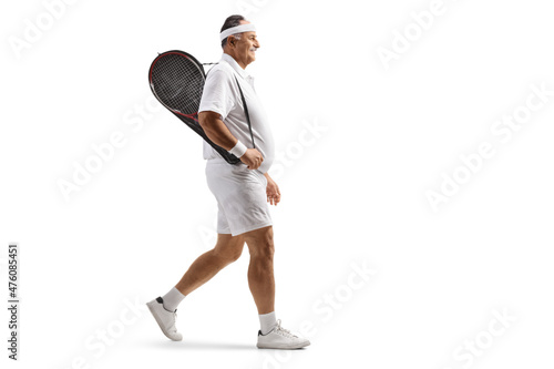 Full length profile shot of a mature man walking with a tennis racket on his shoulder © Ljupco Smokovski