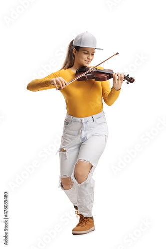 Young female violinist in jeans and yellow top playing a violin