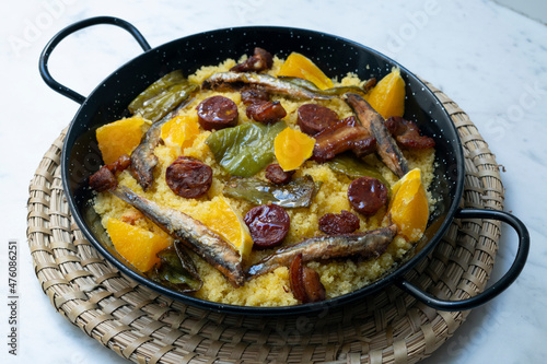 Bread crumbs with chorizo, green pepper, orange, bacon and fried anchovies. Traditional Spanish tapa.