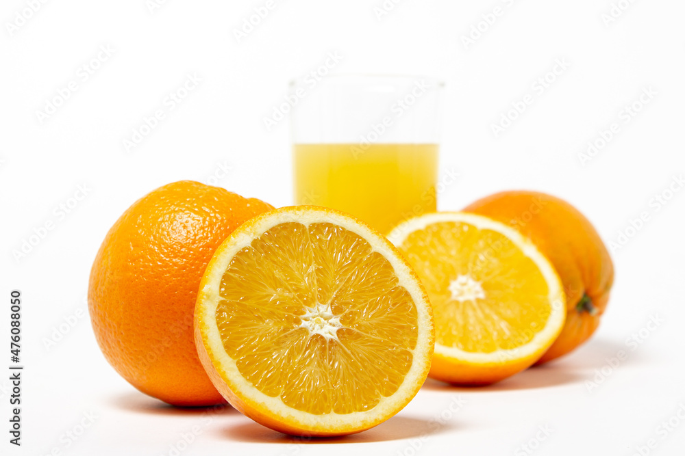 Freshly squeezed orange juice on a white background. A glass of orange juice and a cut orange next to it. Refreshing natural fruit juice Freshly squeezed orange juice on a white background. A glass of orange juice and a cut orange next to it. Refreshing natural fruit juice