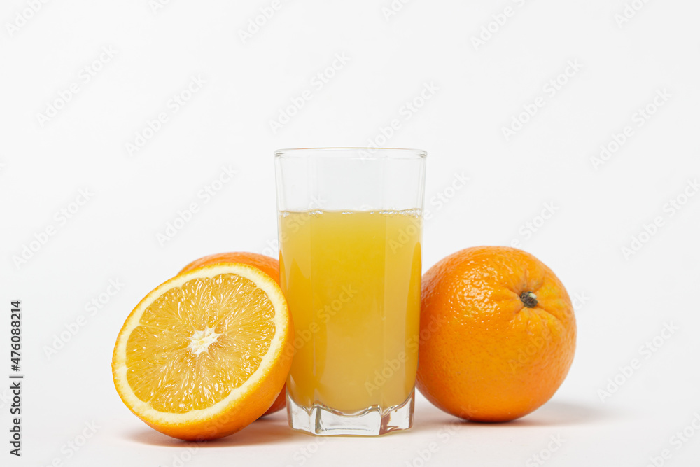 Freshly squeezed orange juice on a white background. A glass of orange juice and a cut orange next to it. Refreshing natural fruit juice Freshly squeezed orange juice on a white background. A glass of orange juice and a cut orange next to it. Refreshing natural fruit juice