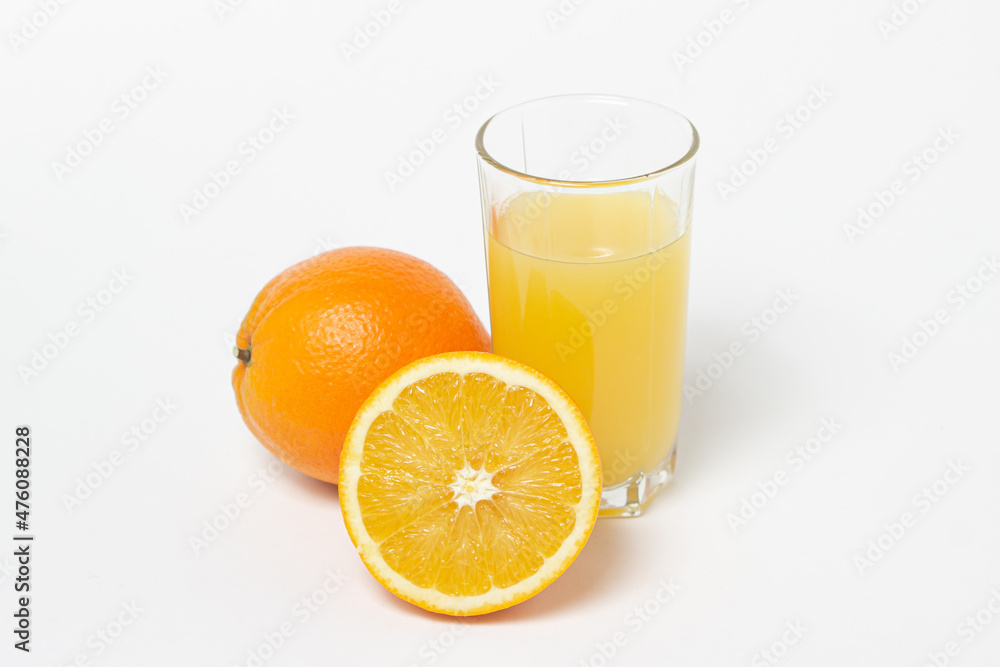 Freshly squeezed orange juice on a white background. A glass of orange juice and a cut orange next to it. Refreshing natural fruit juice Freshly squeezed orange juice on a white background. A glass of orange juice and a cut orange next to it. Refreshing natural fruit juice