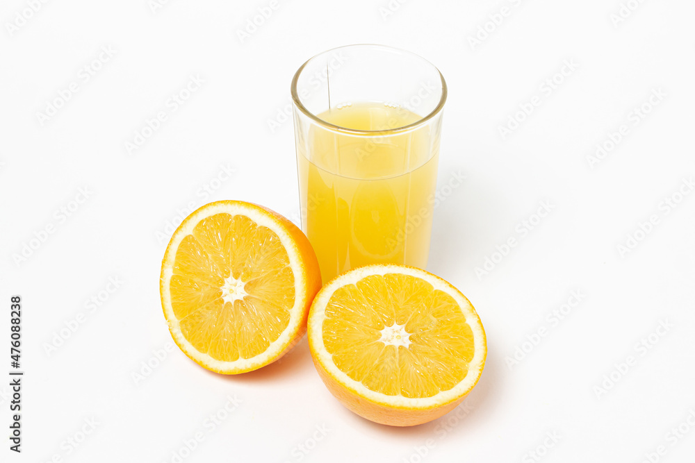 Freshly squeezed orange juice on a white background. A glass of orange juice and a cut orange next to it. Refreshing natural fruit juice Freshly squeezed orange juice on a white background. A glass of orange juice and a cut orange next to it. Refreshing natural fruit juice