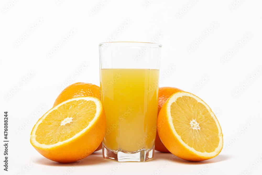 Freshly squeezed orange juice on a white background. A glass of orange juice and a cut orange next to it. Refreshing natural fruit juice Freshly squeezed orange juice on a white background. A glass of orange juice and a cut orange next to it. Refreshing natural fruit juice
