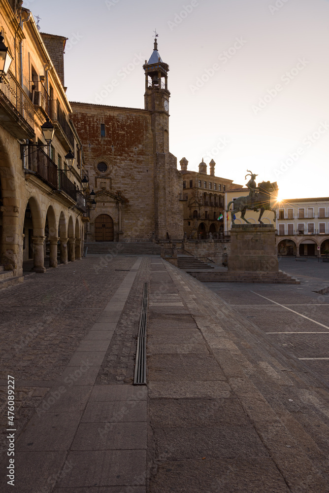 City landscape of the main square of the medieval old town of Trujillo with the Catholic Church of San Martin and the equestrian statue of Francisco Pizarro at sunrise, Caceres, Extremadura, Spain