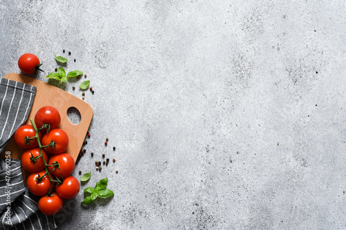 Wooden board with spices and tomatoes. Food photo with a napkin on a concrete background with a place for the text.