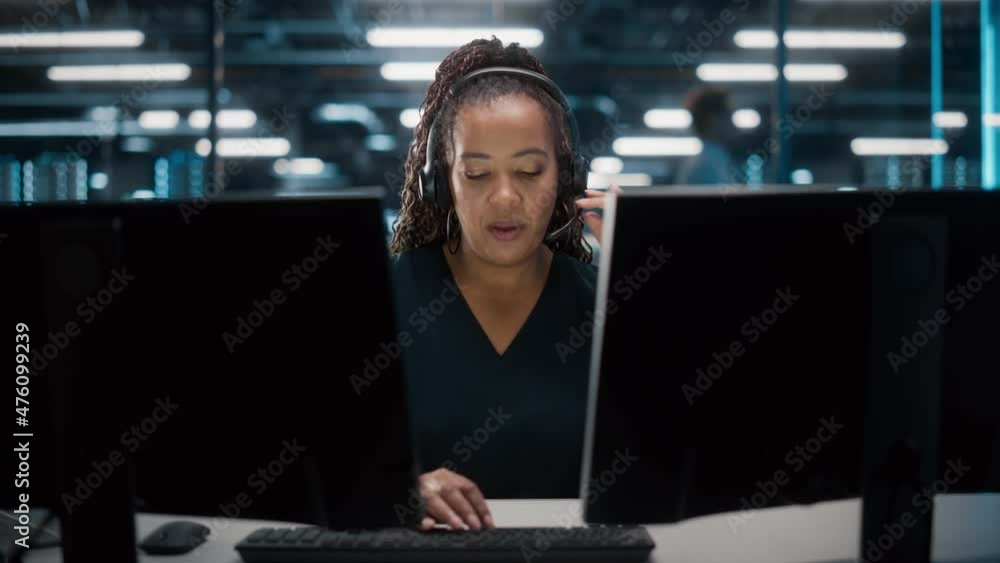 Call Center Office: Portrait of Friendly African American Female Technical Customer Support Specialist Talking on a Headset, uses Computer. Client Experience Officer Helps Online via Video Conference