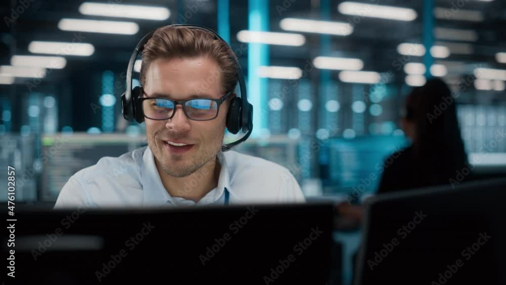 Call Center Office: Portrait of Friendly Caucasian Male Technical Customer Support Specialist Talking on a Headset, uses Computer. Client Experience Officer Helps Online via Video Conference