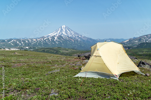 Russia, Kamchatka. Beautiful view of the Vilyuchinsky volcano and a tent in foreground. photo