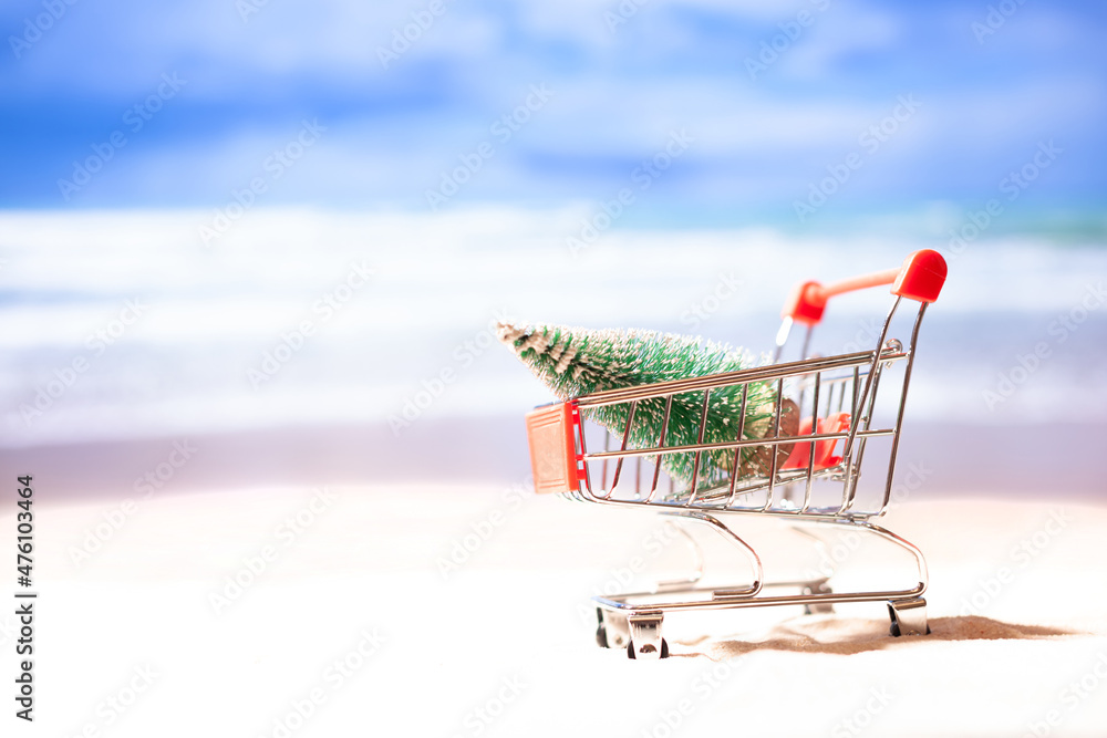 Supermarket cart with christmas tree on the beach, copy space, concept Supermarket cart with christmas tree on the beach, copy space, concept