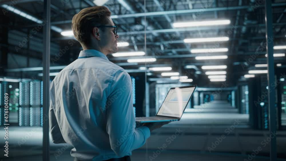 Big Data Center Technology Officer Using Laptop Computer. Server Farm Cloud Computing Facility with System Administrator Working. Software as Solution and Cloud Computing with Cyber Security Big Data Center Technology Officer Using Laptop Computer. Server Farm Cloud Computing Facility with System Administrator Working. Software as Solution and Cloud Computing with Cyber Security