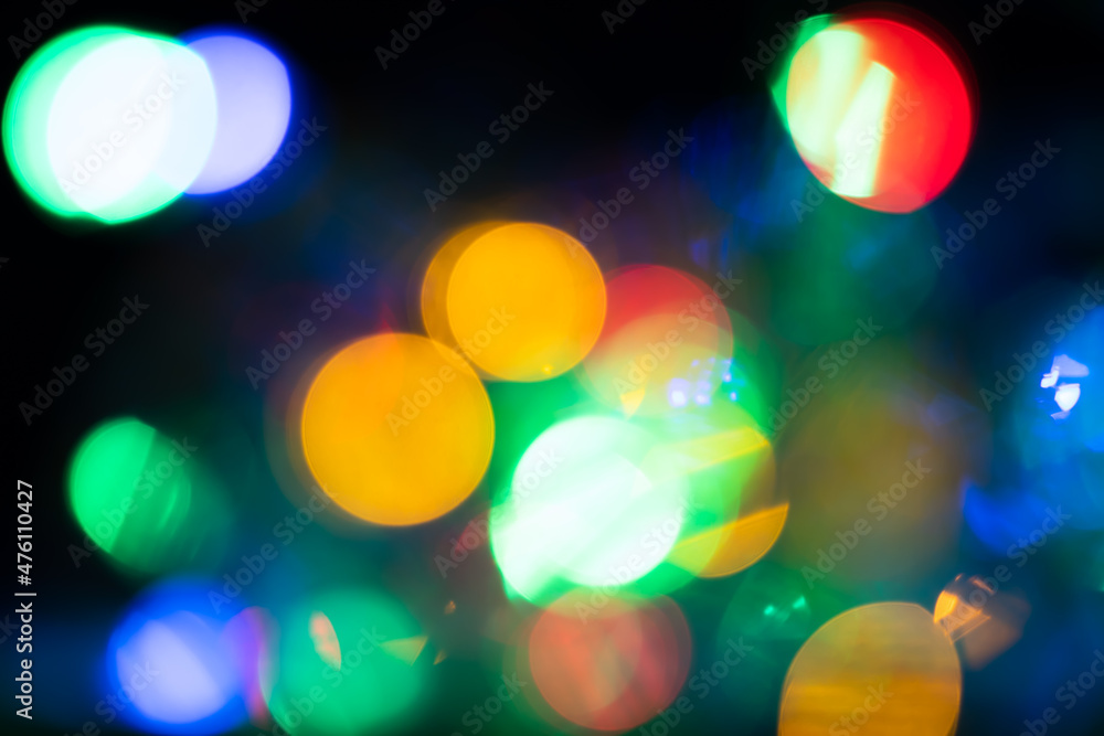 defocused colorful bokeh lights of a garland. beautiful abstract background. Blurred and glowing lights. Christmas mood, valentines day, holiday. dark tones. night. defocused colorful bokeh lights of a garland. beautiful abstract background. Blurred and glowing lights. Christmas mood, valentines day, holiday. dark tones. night.