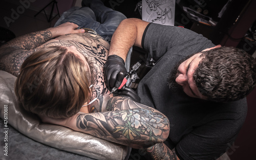 Tattooist and his customer in the workshop