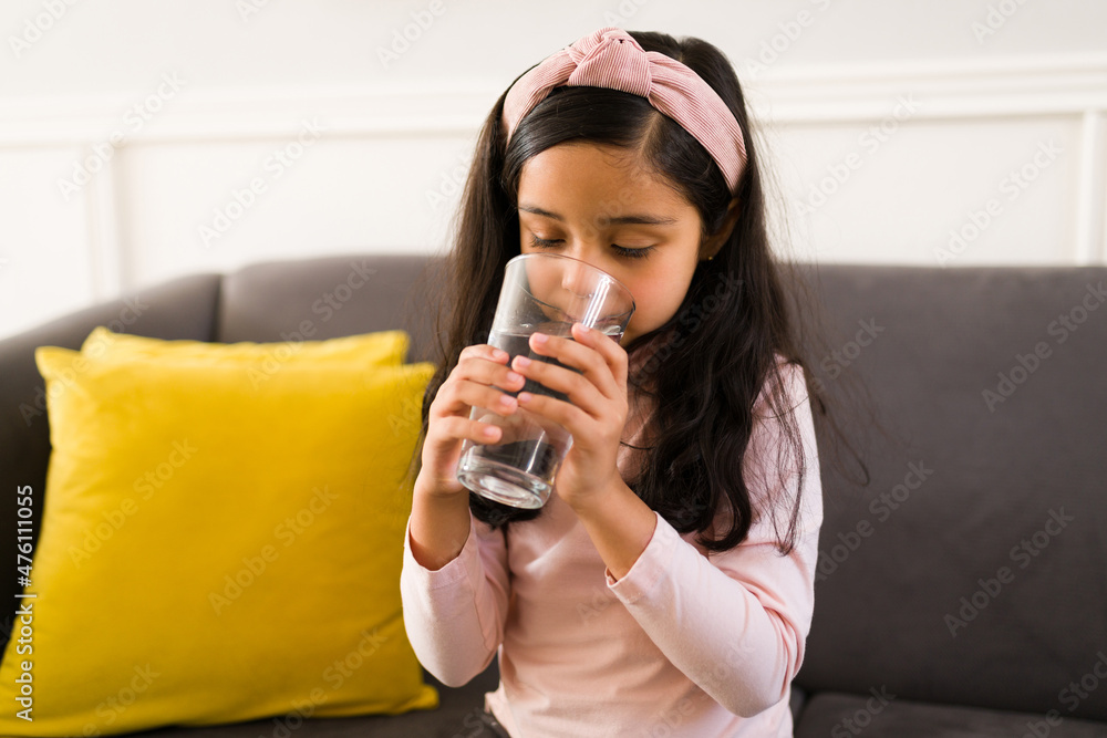 Healthy little girl drinking water
