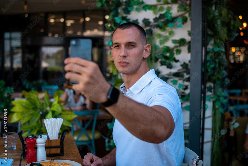 Businessman taking selfie with his smartphone while in a restaurant Businessman taking selfie with his smartphone while in a restaurant