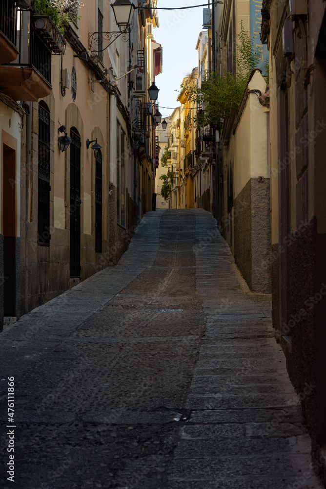 View of a narrow street with stone buildings in the old town of Plasencia at dawn, Caceres, Extremadura, Spain