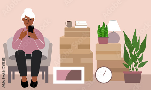 Grandmother at home with a mobile, phone sits in a chair. The concept of online registration of delivery of boxes, goods and assistance in moving.