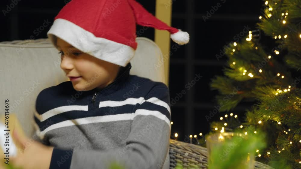Close-up of a boy in a New Year's hat rejoicing at a New Year's gift. New Year Close-up of a boy in a New Year's hat rejoicing at a New Year's gift. New Year