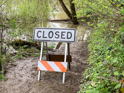 Closed sign on a trail due to flooding water