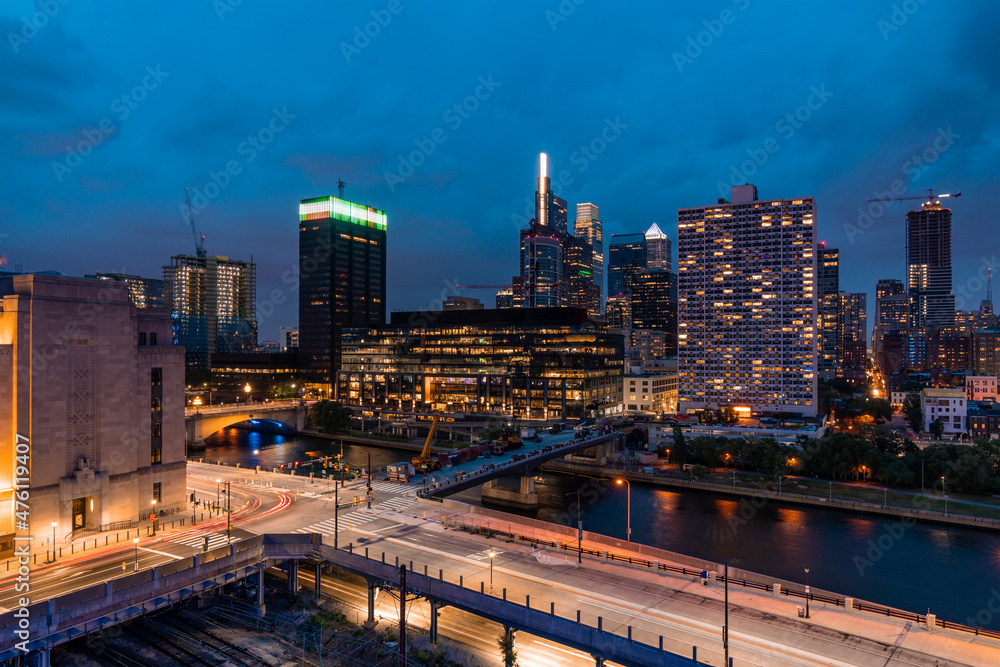 Aerial panoramic city view of Philadelphia financial downtown, Pennsylvania, USA. Chestnut Street Bridge and Market Bridge over Schuylkill River at night time. The economic and cultural center