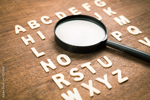 Magnifying glass in English alphabetical order from A-Z wood letters, learning English language, vocabulary and glossary, find the right word to communicate photo