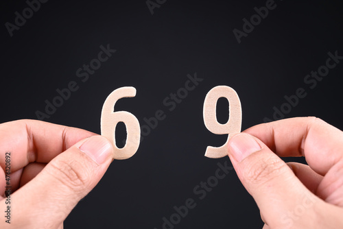 Closeup hands pick the two similar wooden numbers in an opposite direction, confuse what number is this, 6 or 9 points of view, different perspective argument