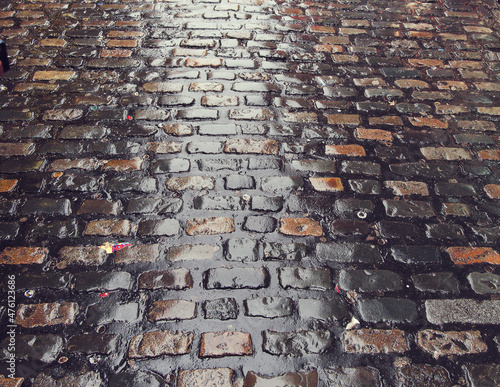 Fotografie Wet cobble road surface after a rain