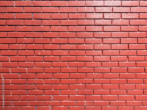 Brick wall texture painted with red saturated color. Masonry craft and industry. Abstract background