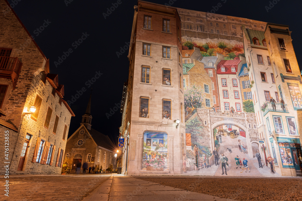 Naklejka premium Quebec, Canada - October 18 2021 : Fresco Wall Art in the Quebec City Old Town in autumn night. Mural of Quebecers.