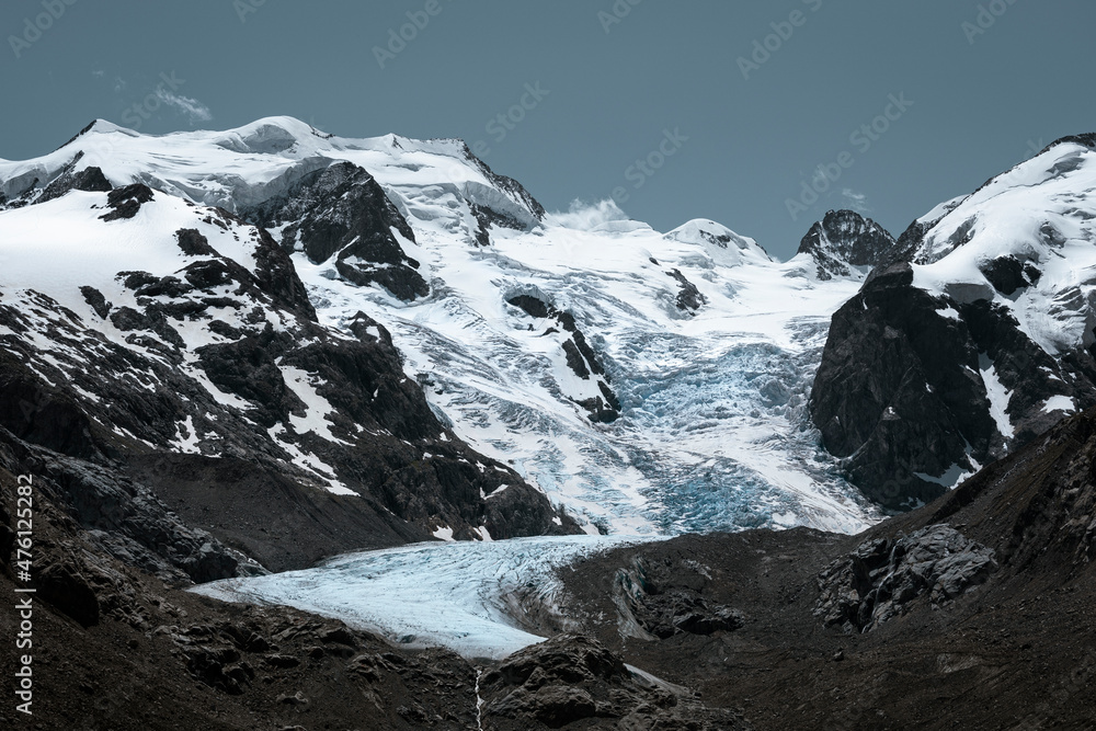 Morteratsch Glacier with snowy mountains in the Engadin in the Swiss Alps in summer, sun and blue sky.