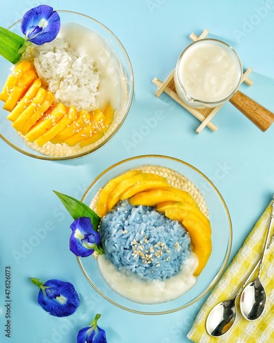 Thai Sweet Blue Sticky Rice with Mango or Khao Nieow Ma Muang. Variation of Mango Sticky Rice with blue sticky rice from blue pea flower. Sprinkle with toasted sesame seeds and coconut milk sauce. photo