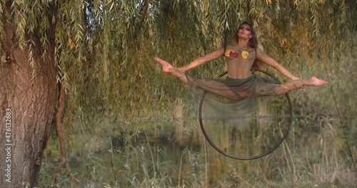 Amazing gymnastics, woman is doing a split on a hoop, spinning, dryad cosplay 4k